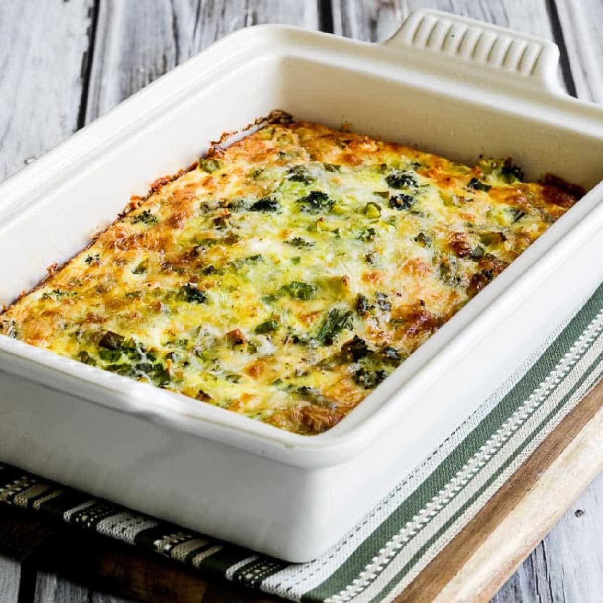 Square image for Broccoli and Three Cheese Keto Breakfast Casserole shown in baking dish on napkin.